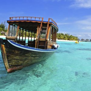 Maldivian dhoni in front of the turquoise bay and island